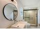 Stylish bathroom features modern sink, round mirror, and glass enclosed shower with decorative tile at 415 Courbet Dr # 415, Nokomis, FL 34275