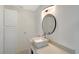 Bright bathroom with a modern vessel sink, sleek faucet, stylish light fixture, and a round mirror at 415 Courbet Dr # 415, Nokomis, FL 34275
