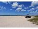 Expansive beach with white sand, clear water, and open views of the horizon and dark green all terrain vehicle at 415 Courbet Dr # 415, Nokomis, FL 34275
