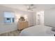 Bedroom features a ceiling fan, dresser, window view, and access to closet and ensuite bath at 415 Courbet Dr # 415, Nokomis, FL 34275