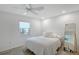Cozy bedroom features a ceiling fan, a bright window, and light wood flooring throughout the space at 415 Courbet Dr # 415, Nokomis, FL 34275
