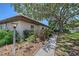 Exterior angle showcasing manicured landscaping, a walkway, and the tiled roof of the property at 415 Courbet Dr # 415, Nokomis, FL 34275