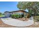 Exterior view of home featuring a detached garage, lush landscaping, and tiled roofing at 415 Courbet Dr # 415, Nokomis, FL 34275