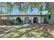 Charming home exterior featuring arched entryways, a tiled roof, and mature landscaping with shade trees at 415 Courbet Dr # 415, Nokomis, FL 34275