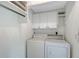 Well-lit laundry room with white washer and dryer, overhead cabinets, and ample storage space at 415 Courbet Dr # 415, Nokomis, FL 34275