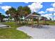Inviting picnic area with wooden picnic tables, green grass, palm trees, and ample shade for outdoor gatherings at 415 Courbet Dr # 415, Nokomis, FL 34275