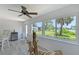 Light-filled sunroom features lake views, access to the outdoors, a ceiling fan, and a unique driftwood art piece at 415 Courbet Dr # 415, Nokomis, FL 34275
