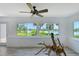 Bright sunroom boasts scenic lake views through expansive windows, ceiling fan, and features unique driftwood art piece at 415 Courbet Dr # 415, Nokomis, FL 34275