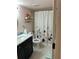 Updated bathroom boasts a navy vanity, floral shower curtain, and decorative gold accents for a stylish touch at 433 Cerromar Ln # 331, Venice, FL 34293