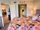 Bright bedroom with floral bedding, views to the kitchen and bath, and neutral walls at 433 Cerromar Ln # 331, Venice, FL 34293