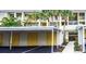 Exterior of condominium with palm trees, carports and covered walkway to the building entrance at 433 Cerromar Ln # 331, Venice, FL 34293