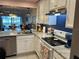 Bright kitchen featuring white cabinets, stainless steel appliances, and a view into the living area at 433 Cerromar Ln # 331, Venice, FL 34293