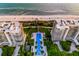 Aerial view of luxury condos with a stunning pool area between the buildings and overlooking the ocean at 435 L Ambiance Dr # K506, Longboat Key, FL 34228