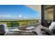 This relaxing balcony offers comfortable seating and panoramic views of the surrounding landscape and blue skies at 435 L Ambiance Dr # K506, Longboat Key, FL 34228