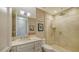 This bathroom is fitted with marble countertops, a framed mirror, and a frameless glass shower at 435 L Ambiance Dr # K506, Longboat Key, FL 34228