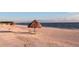 Sandy beach with thatch umbrellas and lounge chairs, perfect for relaxing by the calming ocean at 435 L Ambiance Dr # K506, Longboat Key, FL 34228