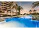 Stunning pool with palm trees and water features, creating a resort-like atmosphere by the modern building at 435 L Ambiance Dr # K506, Longboat Key, FL 34228