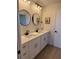 Bright bathroom featuring a double vanity, modern fixtures, round mirrors, and ample storage at 4613 Muirfield Dr, Bradenton, FL 34210