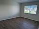 Bright bedroom featuring hardwood floors and a window providing exterior views at 4613 Muirfield Dr, Bradenton, FL 34210