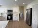 Modern kitchen features white cabinetry, stainless steel appliances and laminate wood flooring at 4613 Muirfield Dr, Bradenton, FL 34210