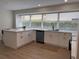 Modern kitchen showcasing a spacious island, stainless steel dishwasher, and white cabinets at 4613 Muirfield Dr, Bradenton, FL 34210