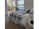 Comfortable bedroom featuring a queen-size bed, stylish linens, and sliding door access to screened patio at 4613 Muirfield Dr, Bradenton, FL 34210