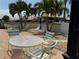 Relaxing pool area offers tables, chairs, and lounge chairs surrounded by palm trees at 4613 Muirfield Dr, Bradenton, FL 34210