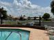 A stunning pool and lake view with community seating with a brick water barrier at 4613 Muirfield Dr, Bradenton, FL 34210