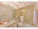 Bright bathroom with a vanity sink, a large mirror, and a shower over tub featuring sliding glass doors at 4726 Potomac Cir, Bradenton, FL 34210
