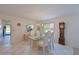Bright dining room featuring a glass table, white chairs, and a view into the kitchen at 4726 Potomac Cir, Bradenton, FL 34210