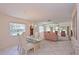 Open dining and living room area with a glass table and a view of the outdoor landscape at 4726 Potomac Cir, Bradenton, FL 34210