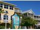 Bright yellow coastal building featuring balconies, large windows, and lush tropical landscaping at 4726 Potomac Cir, Bradenton, FL 34210