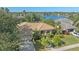 Beautiful aerial view of a lakeside home with a tile roof, lush landscaping, and a private driveway at 4978 Cedar Oak Way, Sarasota, FL 34233