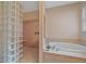 Bathroom showcasing a bathtub, glass block shower, and neutral-toned walls at 4978 Cedar Oak Way, Sarasota, FL 34233