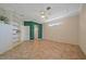 A bright bedroom with tile flooring, ceiling fan, built-in shelving, and a doorway to a walk-in closet at 4978 Cedar Oak Way, Sarasota, FL 34233
