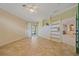 Bedroom showcasing tile floors, neutral walls, ceiling fan, and access to an adjacent room with shelving at 4978 Cedar Oak Way, Sarasota, FL 34233