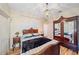 Charming bedroom features a vintage-style bed frame, hardwood floors and decorative chandelier at 4978 Cedar Oak Way, Sarasota, FL 34233