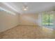 Spacious bedroom featuring tile flooring, ceiling fan, and sliding glass doors for access to outdoor space at 4978 Cedar Oak Way, Sarasota, FL 34233