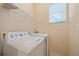 Functional laundry room with washer, dryer, and overhead shelving at 4978 Cedar Oak Way, Sarasota, FL 34233