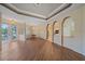 Inviting living area with hardwood floors, decorative columns, tray ceilings, and lots of natural light at 4978 Cedar Oak Way, Sarasota, FL 34233