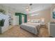 Staged main bedroom with tile flooring, ceiling fan, rug, bed, and green accent wall and shelving at 4978 Cedar Oak Way, Sarasota, FL 34233