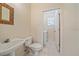 Small powder room with a sink, toilet, and access to the laundry room at 4978 Cedar Oak Way, Sarasota, FL 34233