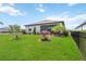 Enjoy the Florida sunshine in this landscaped backyard with lush green grass, palm trees, and a black fence at 5165 Coral Reef Way, Bradenton, FL 34211