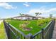 Lush backyard featuring manicured lawn and palm trees, surrounded by a sleek black fence at 5165 Coral Reef Way, Bradenton, FL 34211