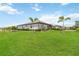 Spacious backyard featuring lush green grass, mature palm trees, and well-maintained landscaping at 5165 Coral Reef Way, Bradenton, FL 34211