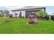 Beautifully landscaped backyard featuring lush green grass, palm trees, and blooming bougainvillea at 5165 Coral Reef Way, Bradenton, FL 34211