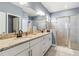 Modern bathroom with double vanity, granite countertop, and a glass-enclosed shower at 5165 Coral Reef Way, Bradenton, FL 34211