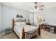 Comfortable bedroom with a metal bed frame, ceiling fan, shuttered window, and ensuite bathroom at 5165 Coral Reef Way, Bradenton, FL 34211