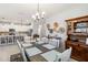 Open dining room with wooden table, white chairs, stylish lighting, and kitchen access at 5165 Coral Reef Way, Bradenton, FL 34211