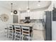 Kitchen island featuring granite countertop, white cabinetry, pendant lights, and bar stool seating at 5165 Coral Reef Way, Bradenton, FL 34211